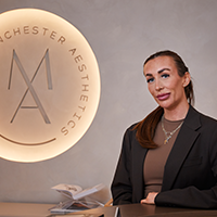 Ellen pictured inside the Manchester Aesthetics clinic with branded background